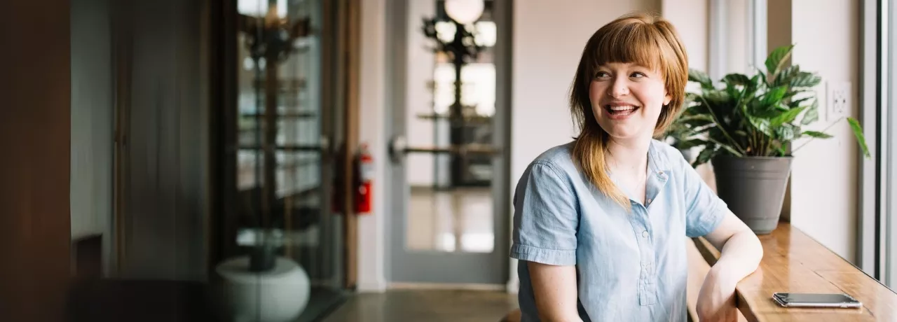 Frau mit roten haaren sitzt am Fenster