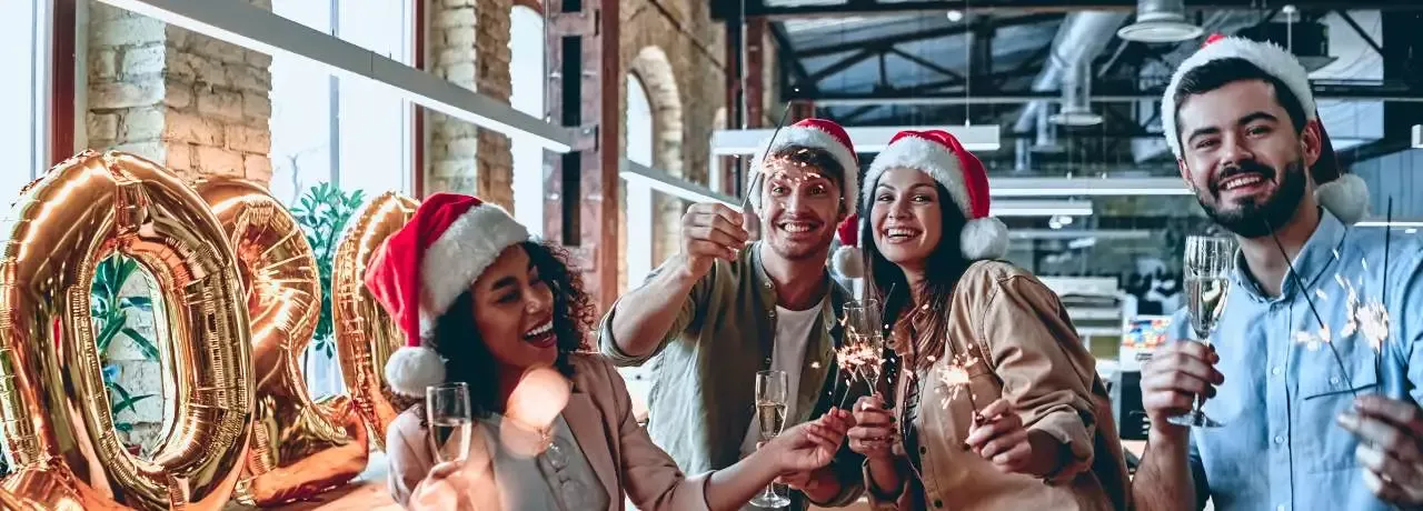 Ein Team von Mitarbeitenden in Weihnachtsstimmung in einem Loftbüro mit Weihnachtsdeko 