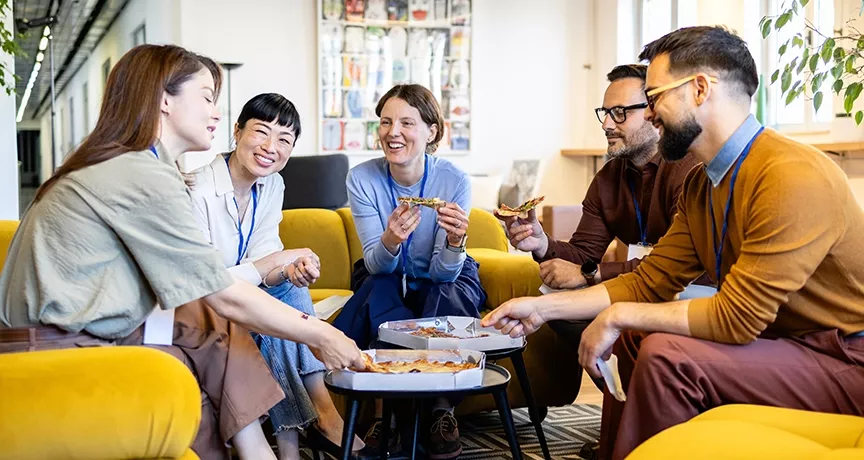 Kolleg:innen tauschen beim gemeinsamen Lunch in der Office-Lobby neue Ideen aus. 