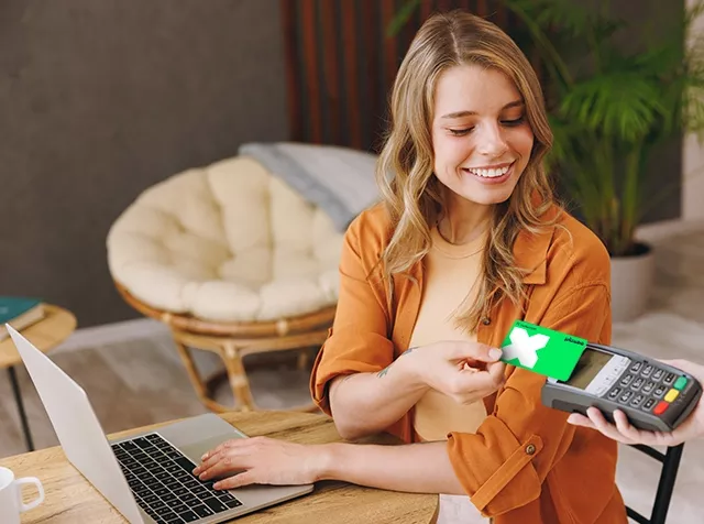 Frau lachend bezahlt mit Karte