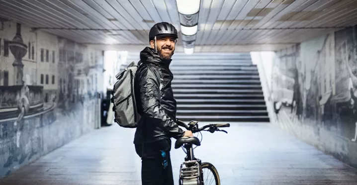 Mann ist mit seinem Dienstrad in der Stadt unterwegs und genießt flexible Mobilität.