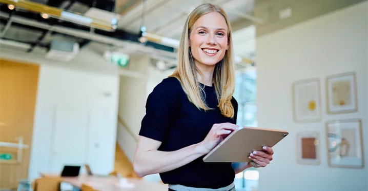 Frau arbeitet engagiert im Büro und trägt zu einem positiven Arbeitsumfeld bei.