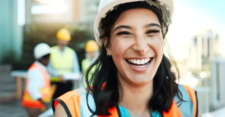 Bauingenieurin arbeitet motiviert im Team und strahlt Freude bei der Arbeit aus.