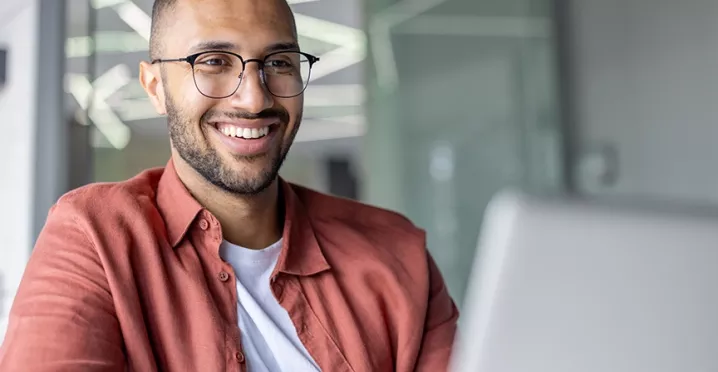 Zufriedener Mitarbeiter arbeitet motiviert und bringt sich engagiert in den Arbeitsalltag ein.