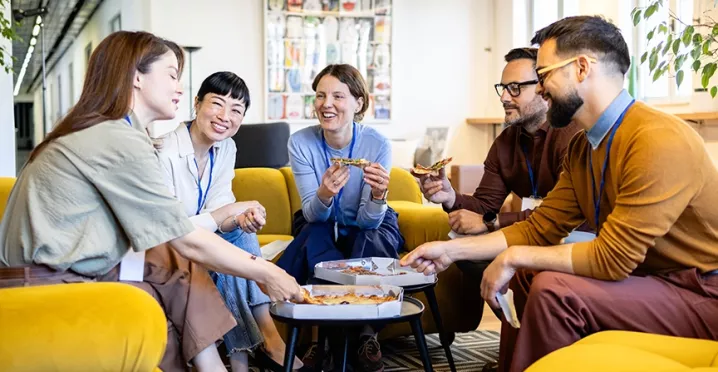 Kolleg:innen tauschen beim gemeinsamen Lunch in der Office-Lobby neue Ideen aus.
