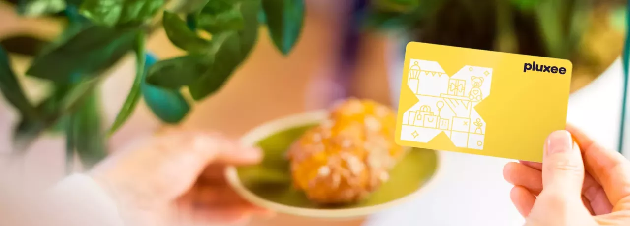 Croissants auf einem Teller mit der Pluxee Benefits Card in gelb