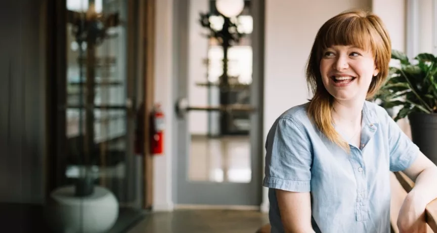 Frau mit roten haaren sitzt am Fenster