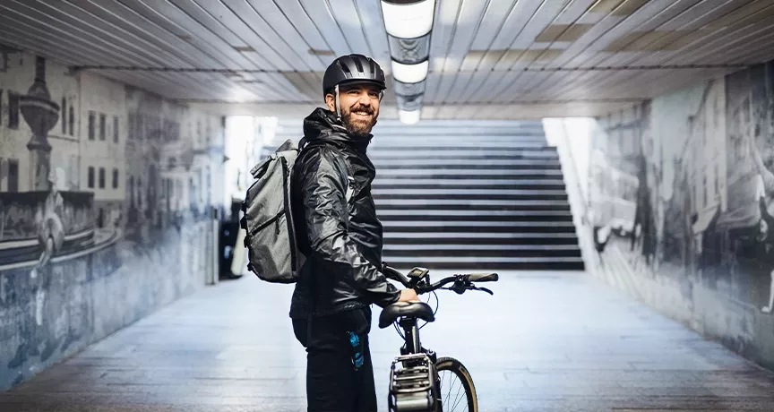 Mann ist mit seinem Dienstrad in der Stadt unterwegs und genießt flexible Mobilität.