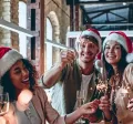 Ein Team von Mitarbeitenden in Weihnachtsstimmung in einem Loftbüro mit Weihnachtsdeko