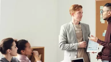 Zwei Menschen unterhalten sich vor einer Seminargruppe. 