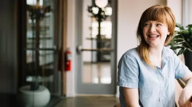 Frau mit roten haaren sitzt am Fenster