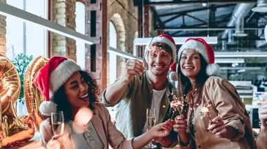 Ein Team von Mitarbeitenden in Weihnachtsstimmung in einem Loftbüro mit Weihnachtsdeko