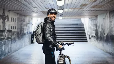 Mann ist mit seinem Dienstrad in der Stadt unterwegs und genießt flexible Mobilität.