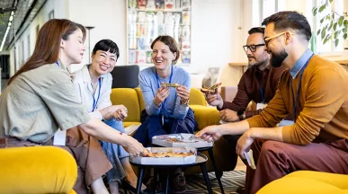 Kolleg:innen tauschen beim gemeinsamen Lunch in der Office-Lobby neue Ideen aus.