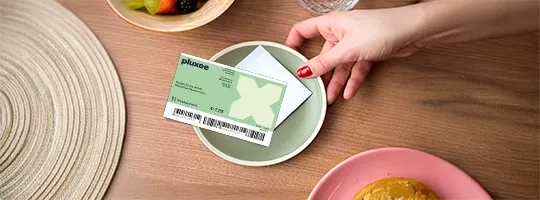 Mitarbeiterin bezahlt ihr Mittagessen mit dem Restaurant Gutschein von Pluxee. 