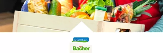 Lebensmittel in einer Holzkiste, von einer Person gehalten, über dem Reformhaus Bacher-Logo.