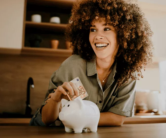 Frau steckt 50 Euro in ein Sparschwein