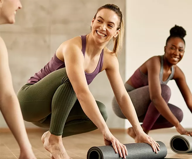 Frauen mit Yogamatte in einem Fitnessstudio – steht für Lebensfreude, Wohlbefinden und die moderne Benefits-Welt von Pluxee.