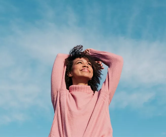 Lächelnde Frau in der Natur – steht für Lebensfreude, Wohlbefinden und die moderne Benefits-Welt von Pluxee.