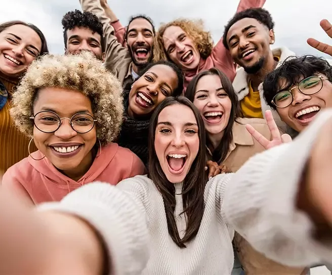 Fröhliche Gruppe von Menschen macht gemeinsam ein Selfie – Symbol für soziales Wohlbefinden, Teamgeist und Gemeinschaft im Pluxee-Kontext.